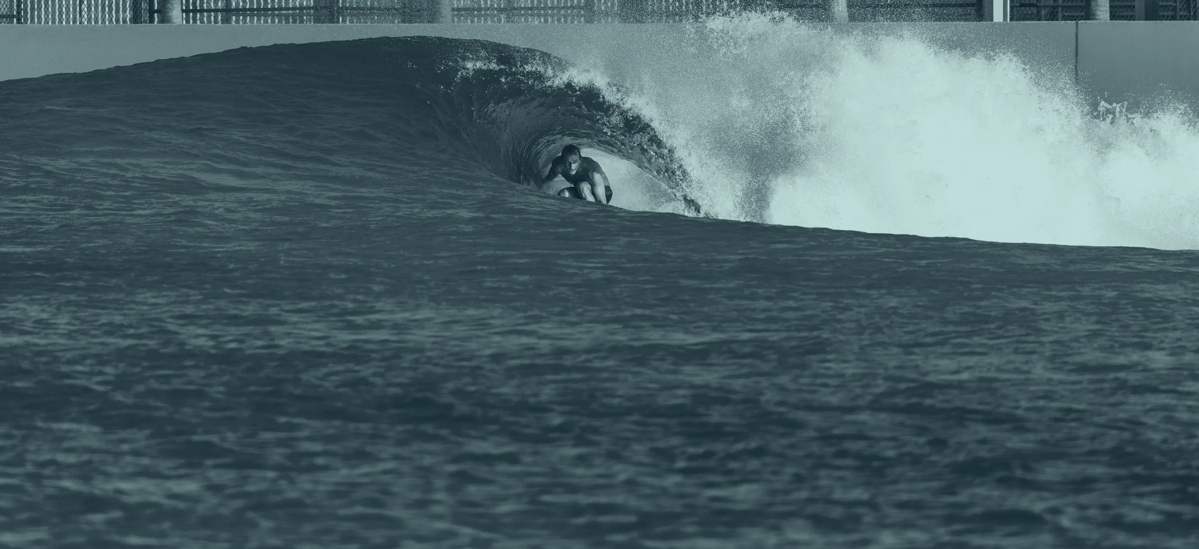 Surfer riding a wave at a wave pool